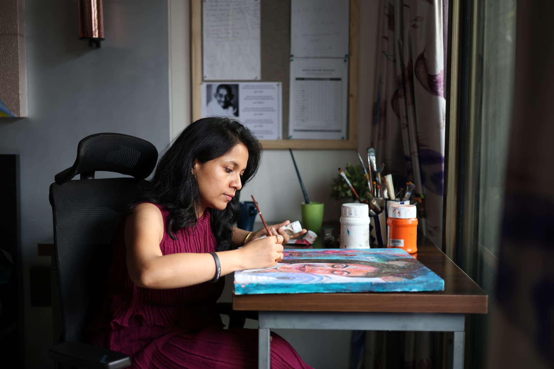 Jayita Dana painting a colourful visionary portrait at her desk